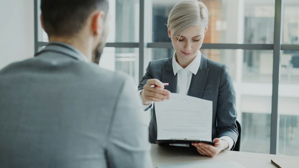 Atendente mostrando um documento ao cliente
